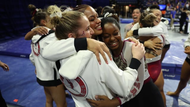 Alabama gymnasts Jordyn Paradise, Makarri Doggette and Lillian Lewis hug to celebrate the victory at Florida